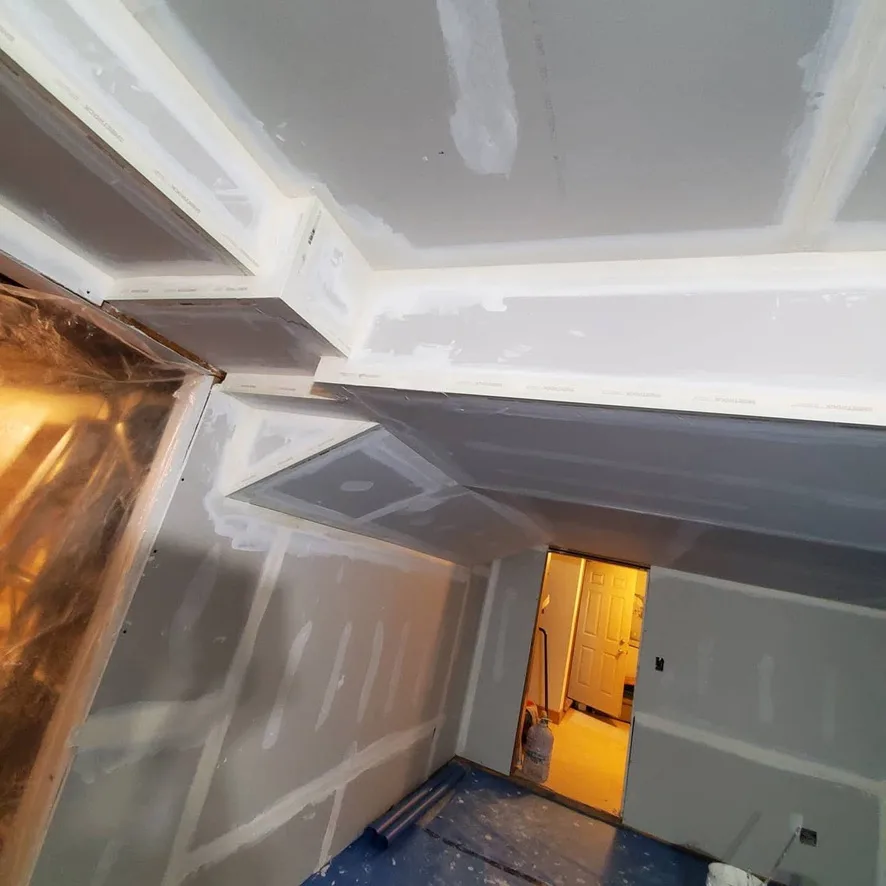 Drywall seams and corners through a stepped ceiling and bulkhead layout.