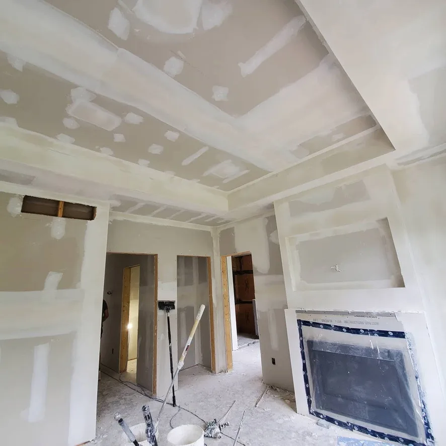 Taped ceiling recesses and wall details around a protected fireplace.