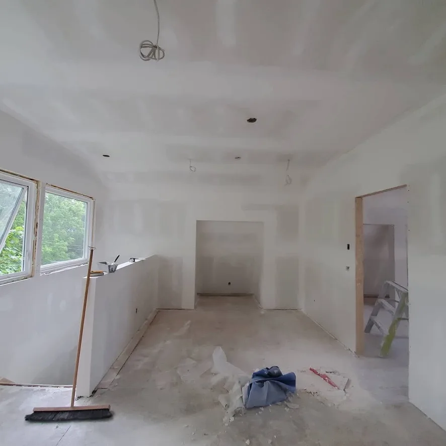 Walls and ceiling through a long room with an adjoining doorway and recessed opening.