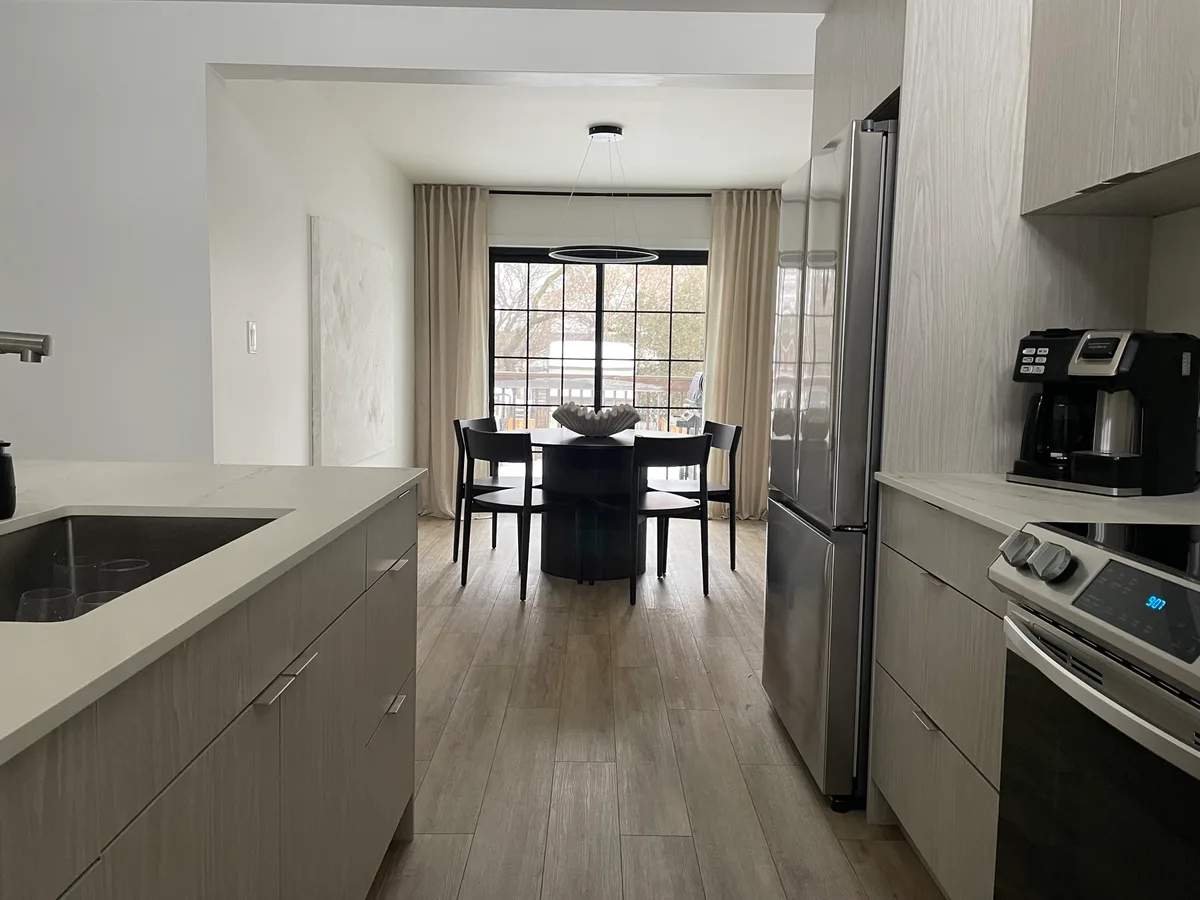 Finished kitchen opening into a dining area with painted walls and ceiling