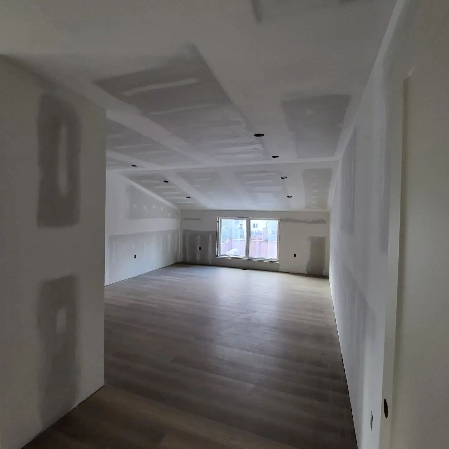 Large open-plan home interior with finished drywall and flooring installed